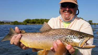 John Hamilton y la hermosa trucha marrón que pescó en el Limay Medio.
