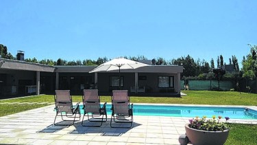 La gran galería cubierta se abre hacia la piscina y el parque. 