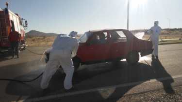 Bomberos voluntarios desinfectan los vehículos que entran a Pilcaniyeu. (Foto Gentileza)