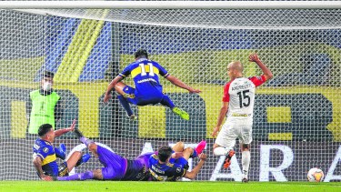 Carlitos Tevez se anticipa a Soldano y a Salvio para marcar el segundo gol de Boca ante el Caracas. El Apache fue una de las figuras. (Foto/AP)