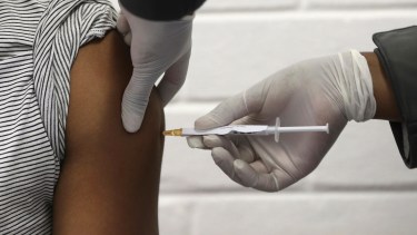FILE - In this Wednesday, June 24, 2020 file photo, a volunteer receives an injection at the Chris Hani Baragwanath hospital in Soweto, Johannesburg, as part of Africa's first participation in a COVID-19 vaccine trial developed at the University of Oxford in Britain in conjunction with the pharmaceutical company AstraZeneca. AstraZeneca says late-stage trials of its COVID-19 vaccine were "highly effective'' in preventing disease. A vaccine developed by AstraZeneca and the University of Oxford prevented 70% of people from developing the coronavirus in late-stage trials, the team reported Monday Nov. 23, 2020. (Siphiwe Sibeko/Pool via AP) Virus Outbreak Britain Vaccine