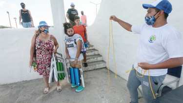 Una escueta soguita para delimitar, en la playa de Las Grutas, el espacio ocupado por los grupos convivientes. Eso fue lo que ofrecieron, a modo de prueba piloto, unos jóvenes que el municipio contrató