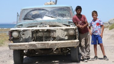 Cristian Firmapaz al volver de hachar leña en las cercanías de Fuerte Argentino. Lo acompaña uno de sus tres hijos. Foto: Luciano Cutrera.