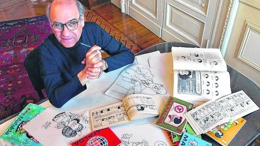 Quino nos mira desde algún lugar con Mafalda sobre la mesa. 