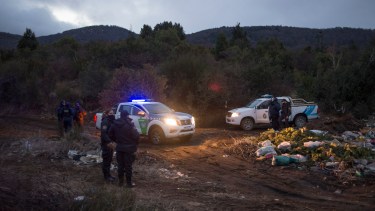 Policías de la comisaría 42, con los patrulleros, bloqueaban este domingo los accesos al predio ocupado. (foto Marcelo Martínez)