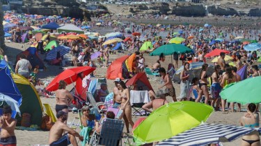 Las Grutas ofreció ayer su clásica postal con cientos de sombrillas. Foto Martín Brunella. 
