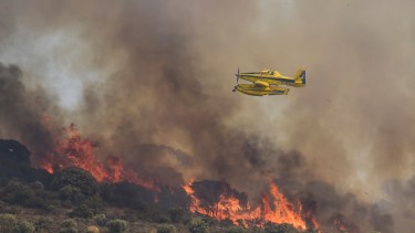 Un avión sobrevuela un incendio forestal en la zona de Chiloeches, en la provincia de Guadalajara, España. Foto: AP 