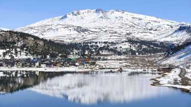 Belleza pura. La aldea de montaña y el volcán Copahue se reflejan en el lago. Foto: Flor Salto. 