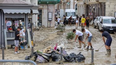 People remove mud from a street in Senigallia, central Italy, Friday Sept. 16, 2022. Flash floods triggered by heavy rain have swept through towns in a hilly central Italy.  Italy's leader Mario Draghi said 10 people were dead in the floods and four were missing. (Guido Calamosca/LaPresse via AP)
