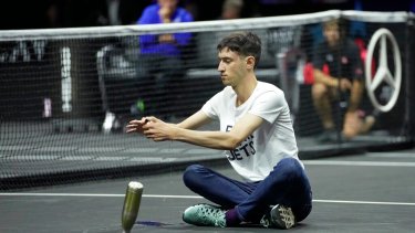 El activista prendió fuego su brazo luego de saltar a la cancha. (AP Photo/Kin Cheung)