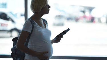 Foto ilustrativa de una mujer embarazada en un aeropuerto. ANNA BORTNIKOVA (GETTY IMAGES).
