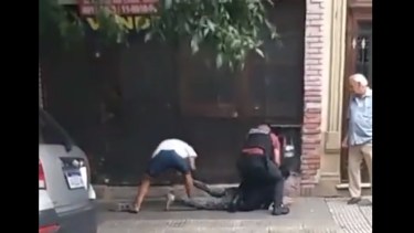 El momento en el que le sacan las zapatillas al ladrón detenido. 
