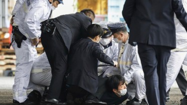 Los policías japoneses se arrojan contra el supuesto autor del atentado.