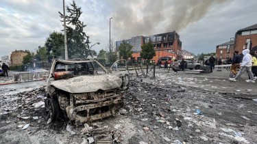 Un vehículo incendiado en una calle frente al edificio del grupo Tessi. Foto AFP. 