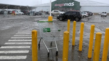 En el exterior del supermercado Changomás hoy predominaba la lluvia y nieve, sin presencial policial externa. Foto: Chino Leiva
