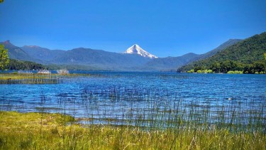 Postal del lago Quillén, belleza pura en la cordillera neuquina. De fondo, un ícono de la Patagonia: el volcán Lanín. 
