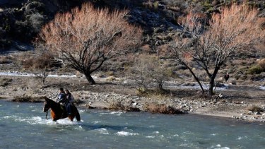 Ailín y sus hermanos Agustín y Valentín deben cruzar a caballo de lunes a viernes el río Cuyín Manzano para asistir a clases en Villa Traful. (foto de archivo de mediados de agosto pasado de Alfredo Leiva)